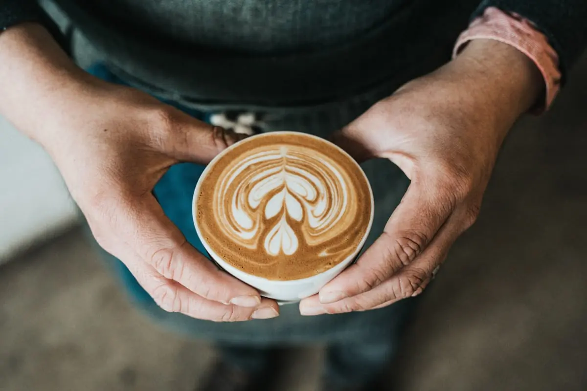 Latte art csésze kézben